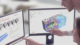 Battery experts analyzing a GeoDict charging simulation of an electrode structure on two screens: one GeoDict application and one results presentation