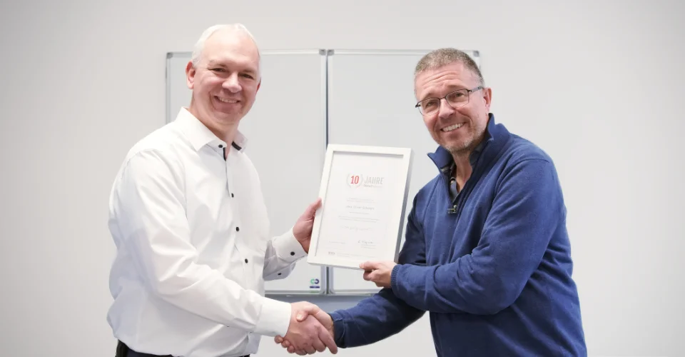 CEO Andreas Wiegmann congratulates Jens-Oliver Schwarz on his 10th anniversary and presents a certificate
